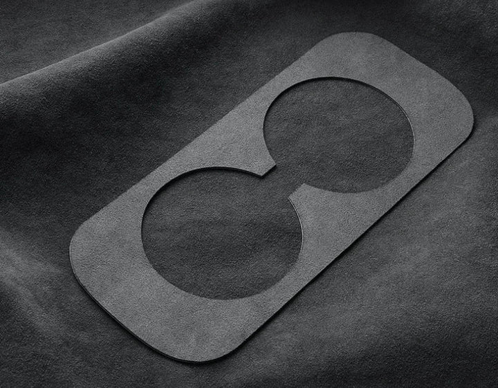 Black leather patch with a unique design on a dark fabric background