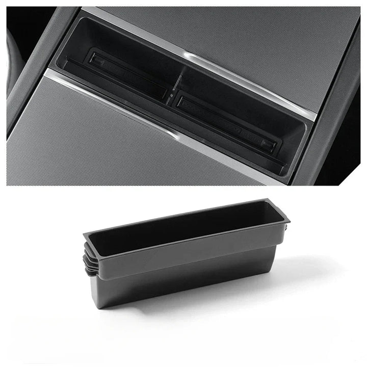 A black or gray central control storage box for Tesla Model 3+ with a label indicating it is a new item for the Tesla Model 3+ Armrest Card Mobile Phone Storage Case.