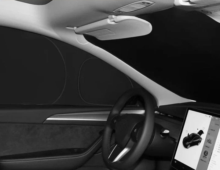 Car window sunshades installed on the interior windshield of a Tesla Model 3, showing the product in use within the vehicle's interior.