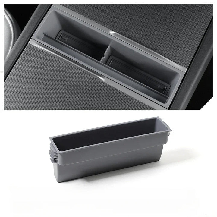 A black or gray central control storage box for Tesla Model 3+ with a label indicating it is a new item for the Tesla Model 3+ Armrest Card Mobile Phone Storage Case.